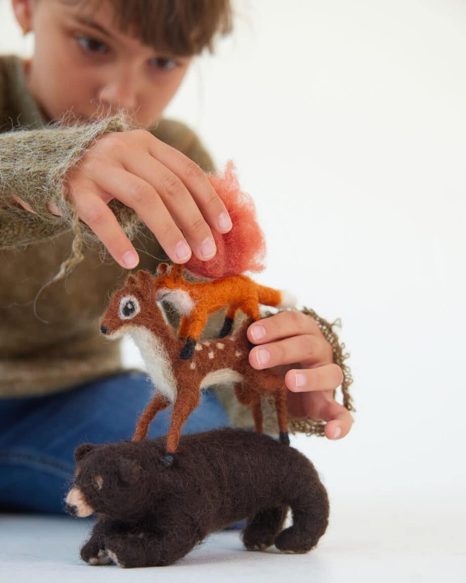 child playing with stacked forest animals