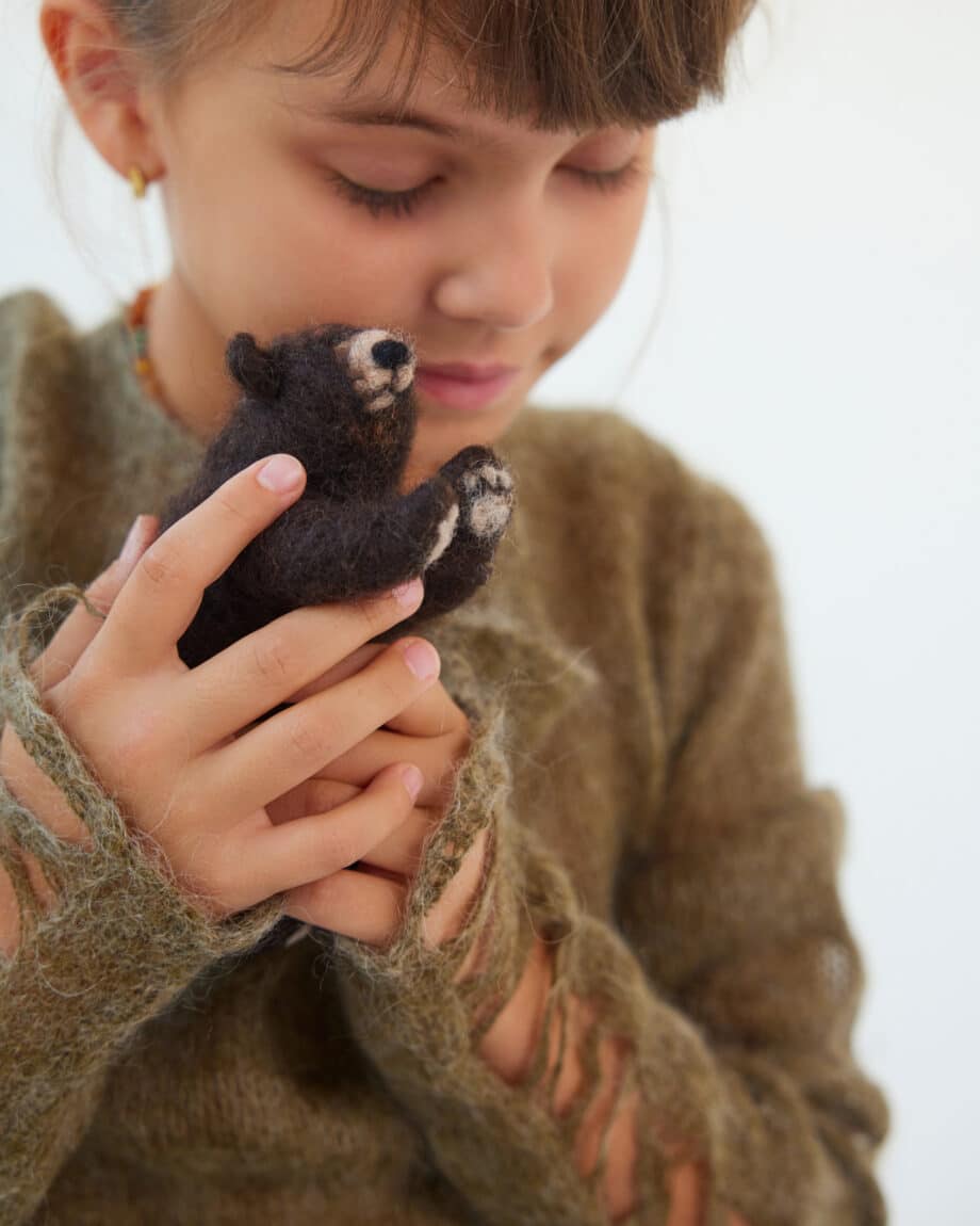 kind dat knuffelt met beertje uit bosdieren set