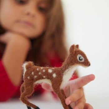 Deer needle felted child plays with deer