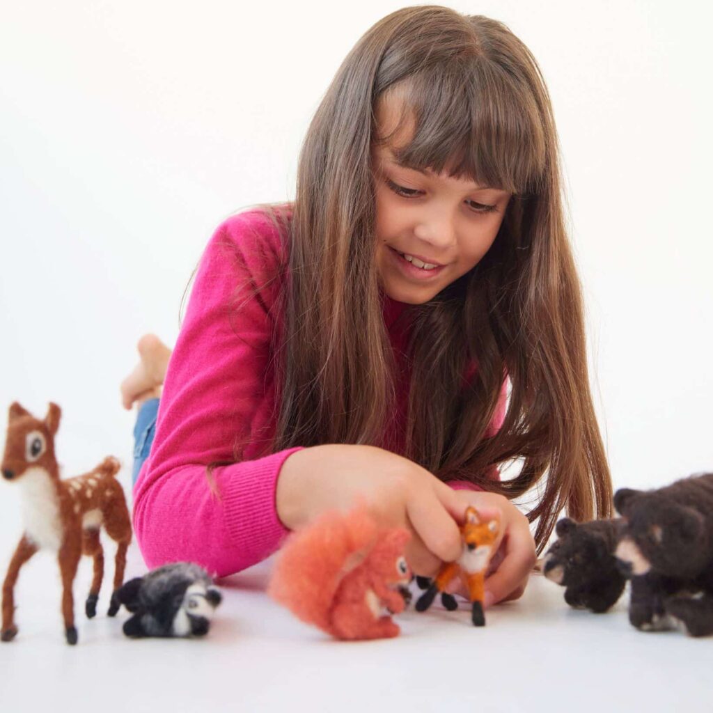 een kind die speelt met de bosdieren uit het bosdierenpakket